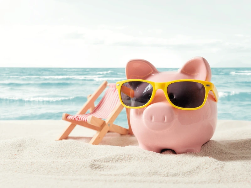 Cheap Beach Vacations-Relaxing tropical beach with palm trees, clear blue water, and budget travelers enjoying an affordable seaside vacation